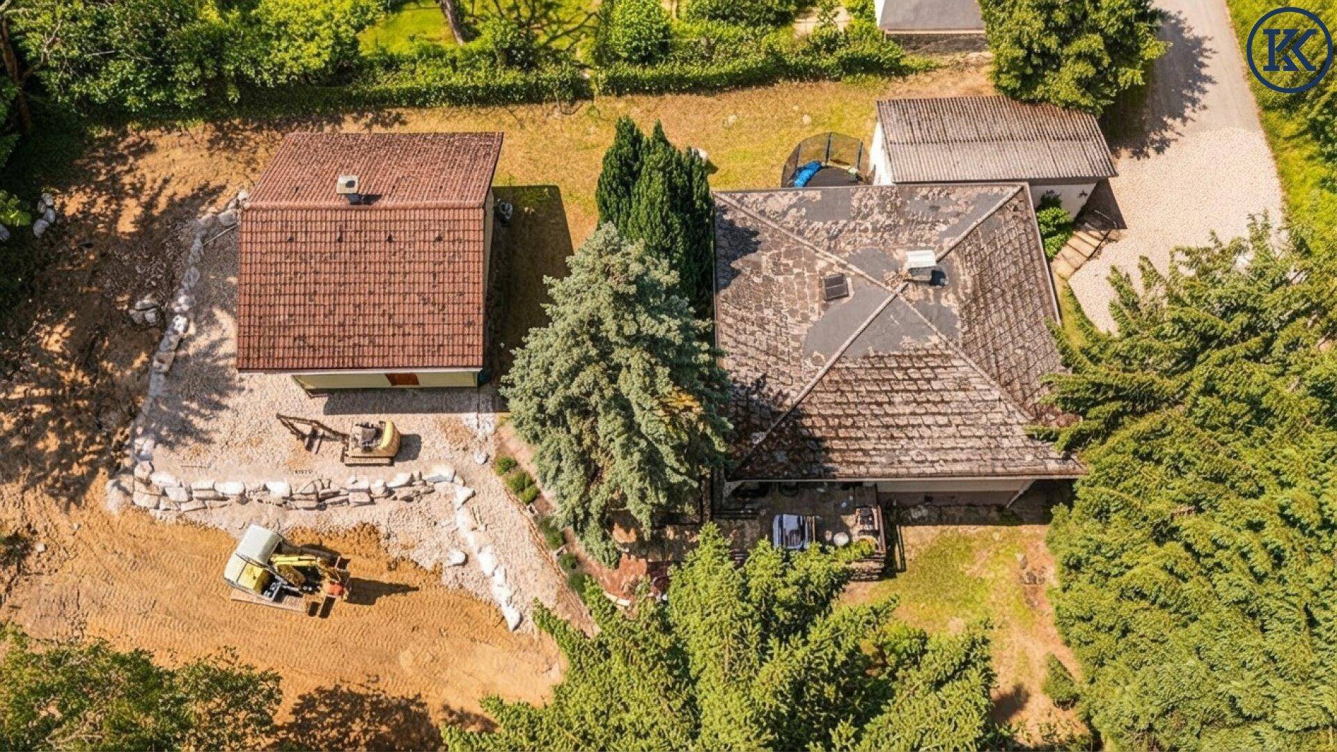 Vogelperspektive des Anwesens mit zwei Gebäuden und Baufortschritt.