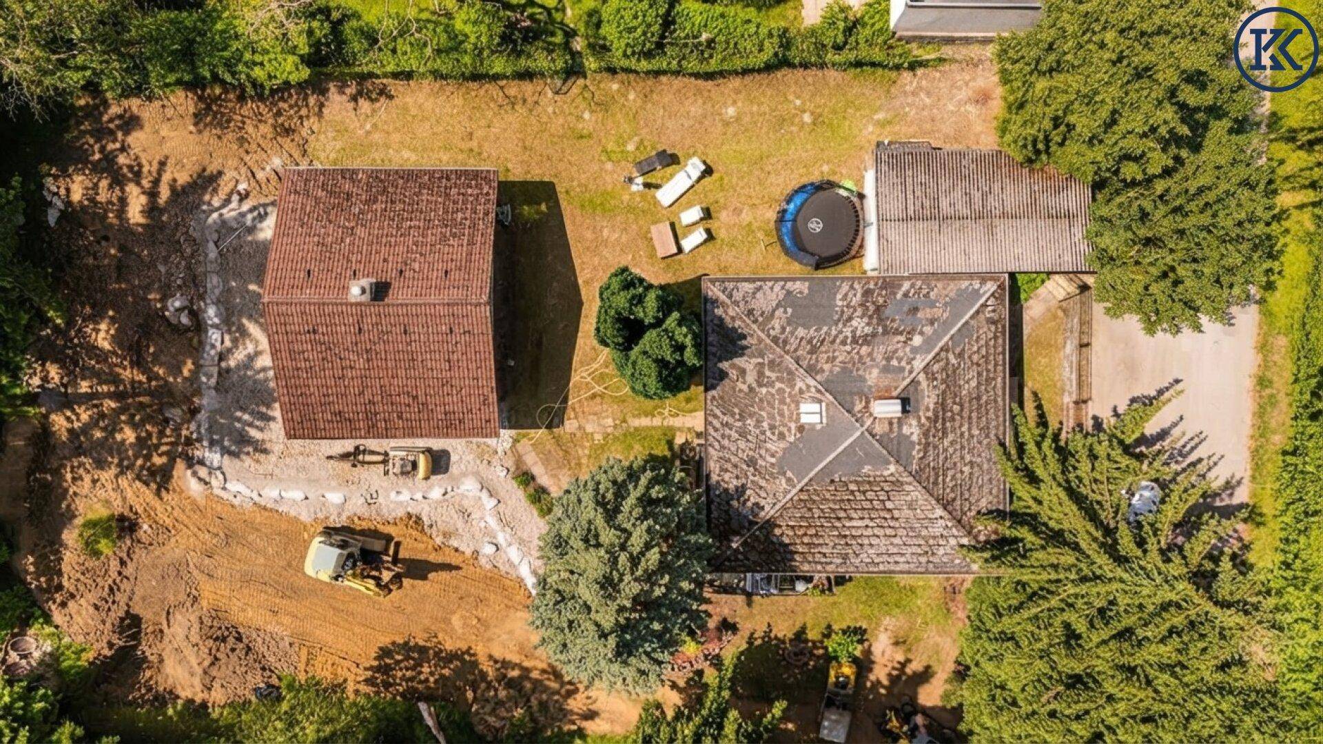 Draufsicht auf das Grundstück mit zwei Häusern und Bauarbeiten.