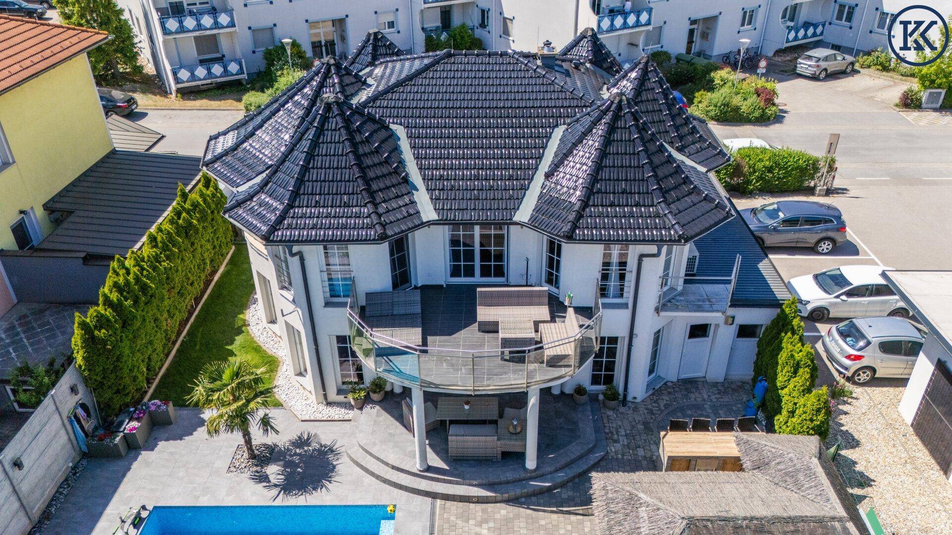 Rückansicht der Villa mit großer Terrasse, bequemen Gartenmöbeln und erfrischendem Pool.