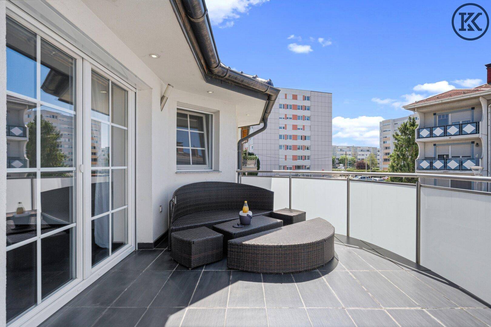 Geräumiger Balkon mit bequemen Lounge-Möbeln und Blick auf die umliegende Bebauung.