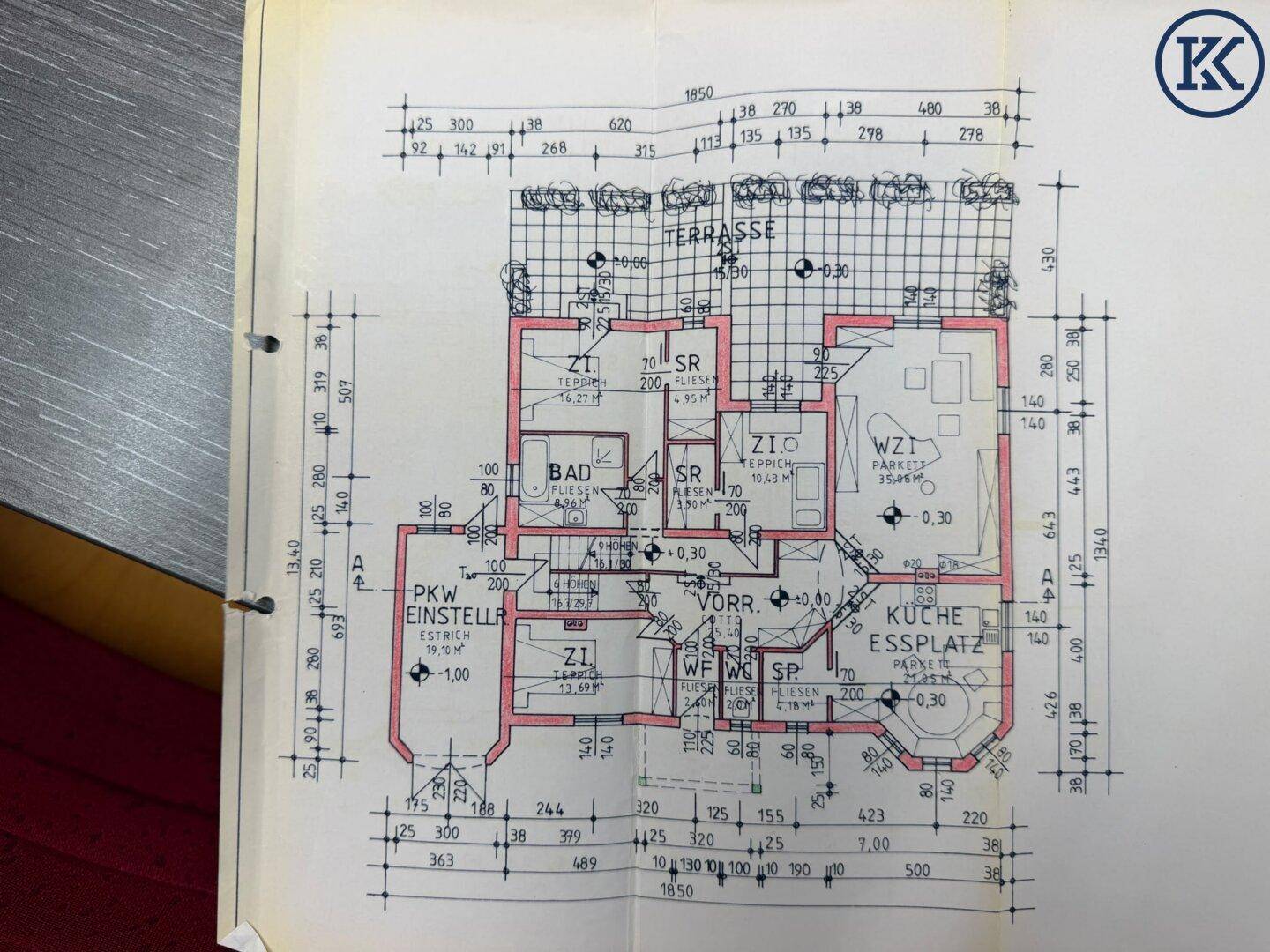Detaillierter Grundriss des Erdgeschosses mit Küche, Bad, Terrasse und Parkplatz.