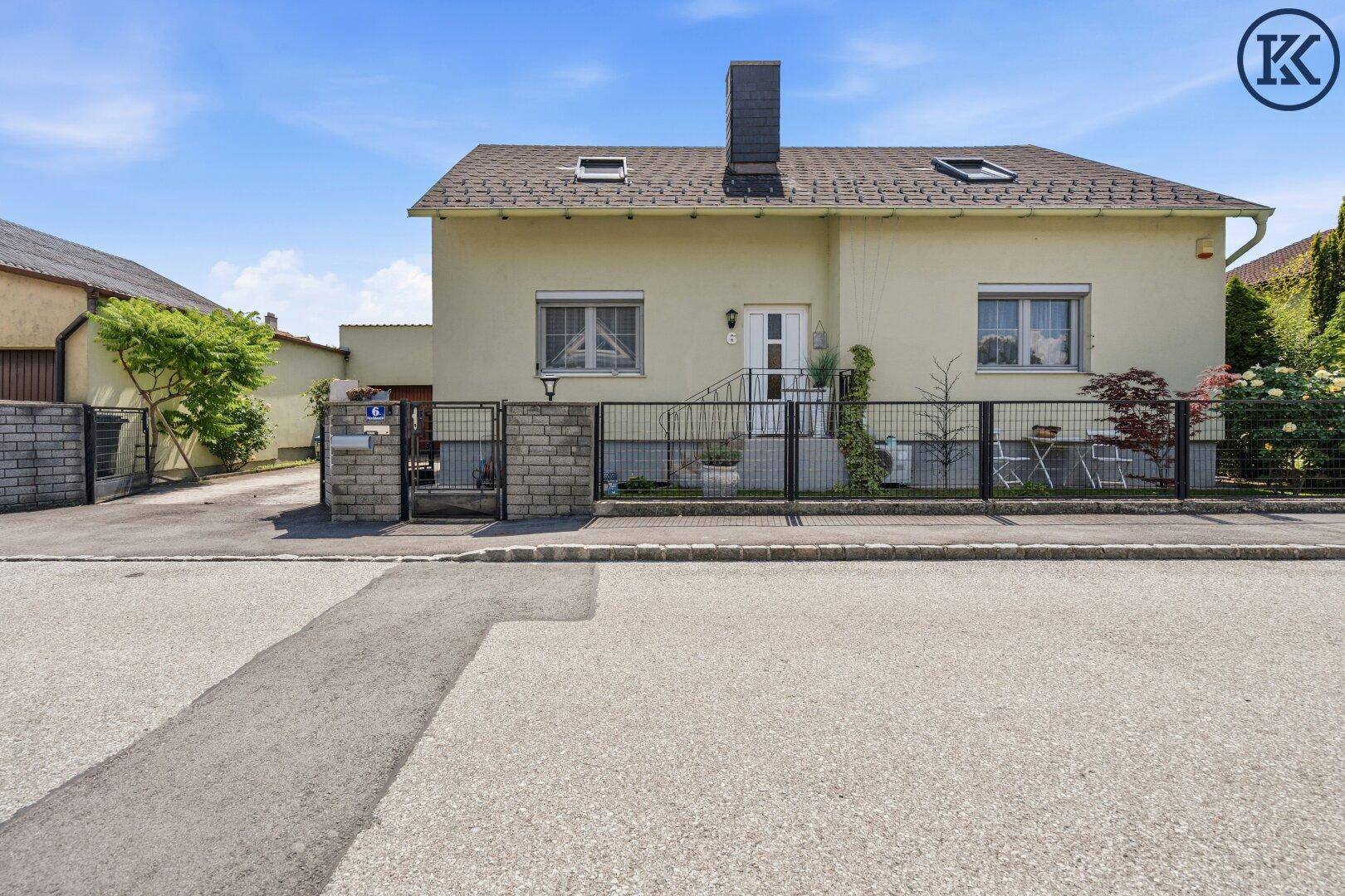 Vorderansicht des Einfamilienhauses von der Straße aus mit Zaun und Vorgarten.