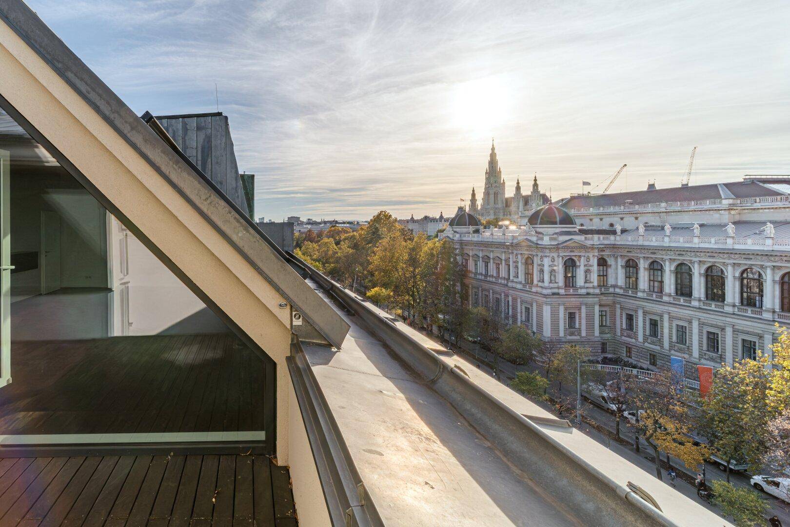 Panoramablick von der Dachterrasse auf die historische Stadtkulisse mit dem Rathaus bei Sonnenuntergang.