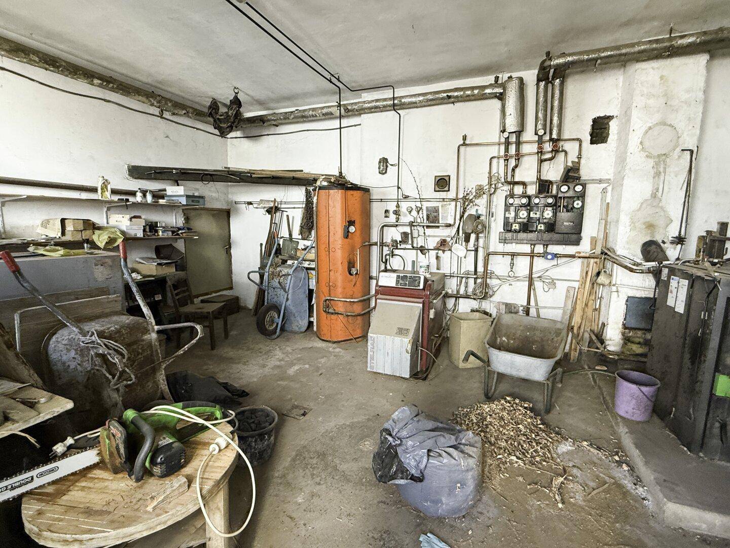 Technikraum mit Heizungsanlage, Warmwasserspeicher und verschiedenen Geräten.