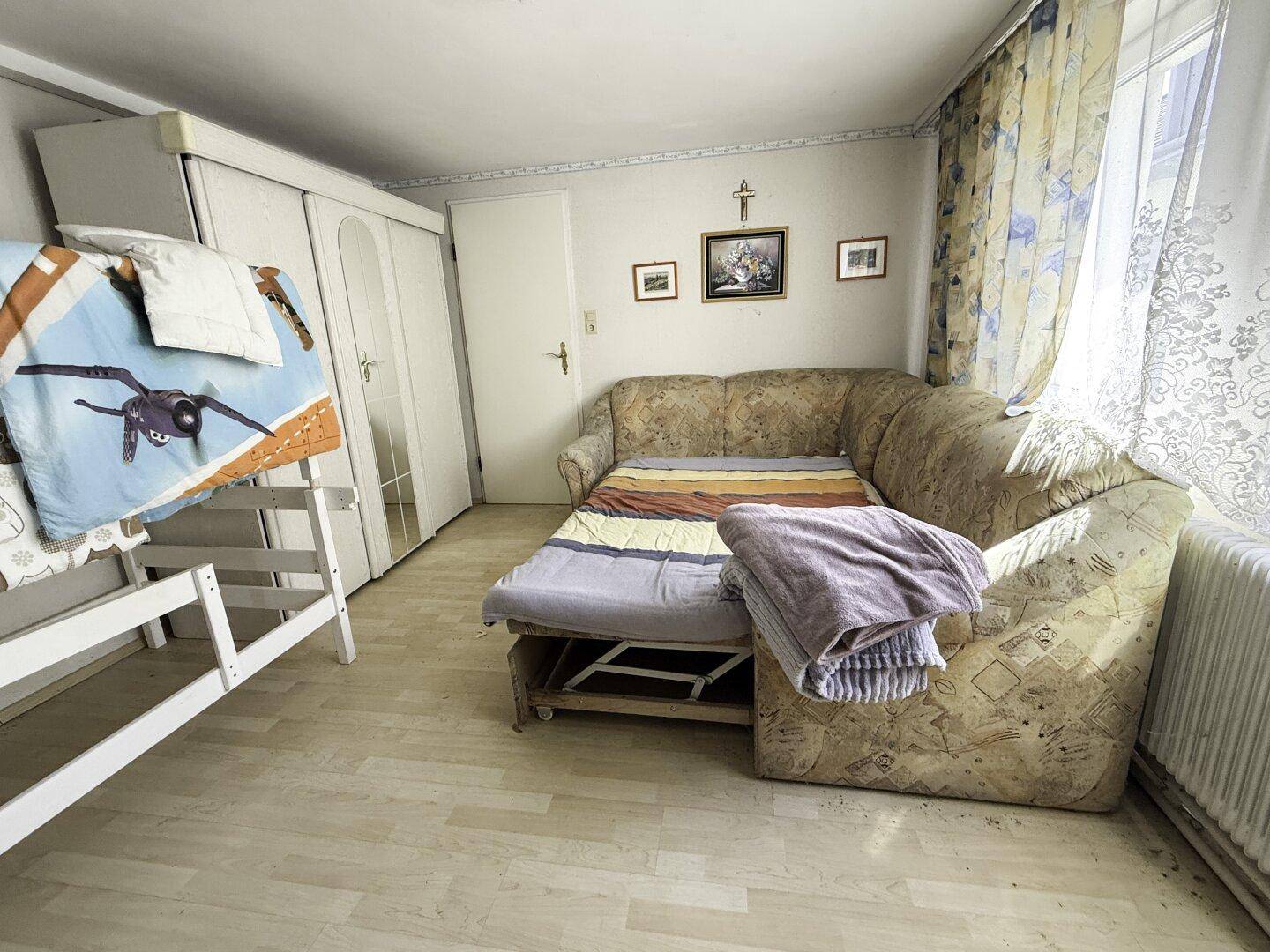 Schlafzimmer mit Schlafsofa, Etagenbett und Kleiderschrank.