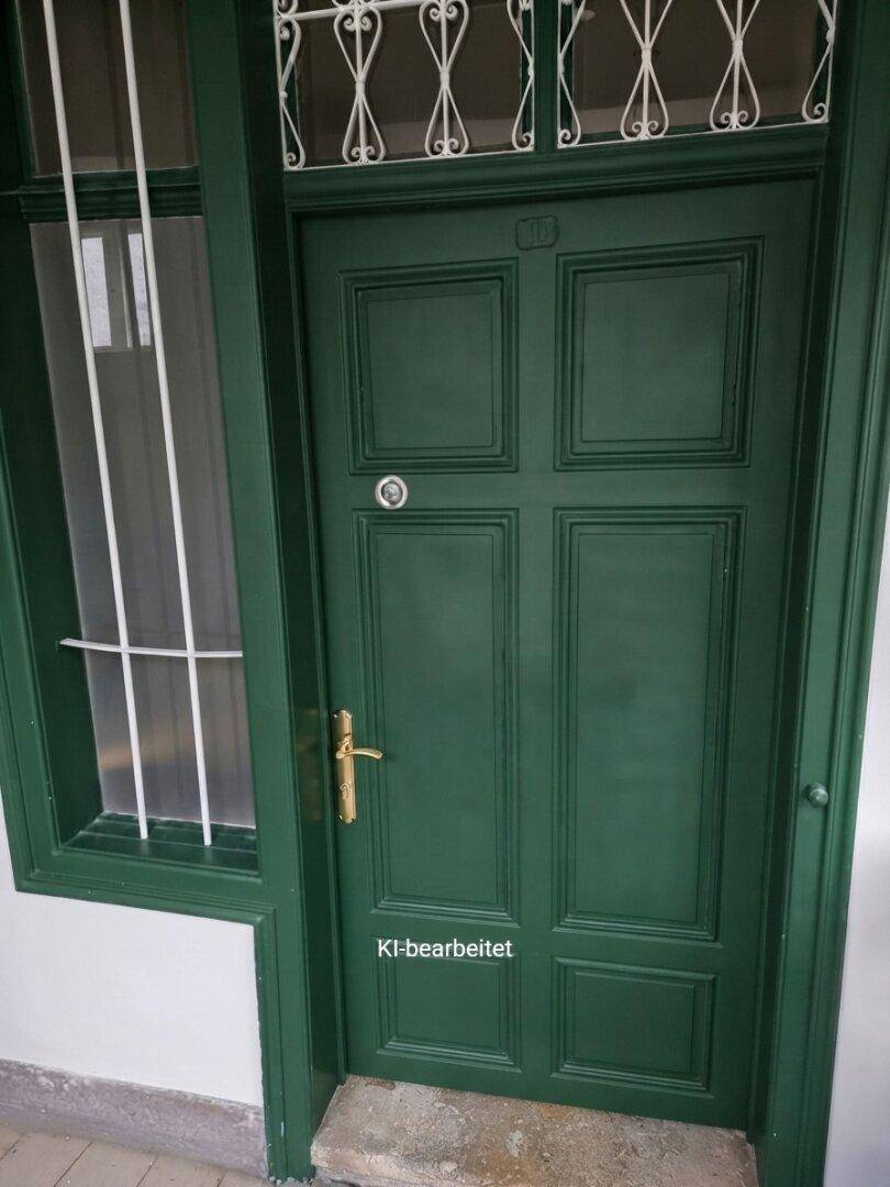 Klassische grüne Eingangstür mit dekorativem Oberlicht und Seitenfenster.