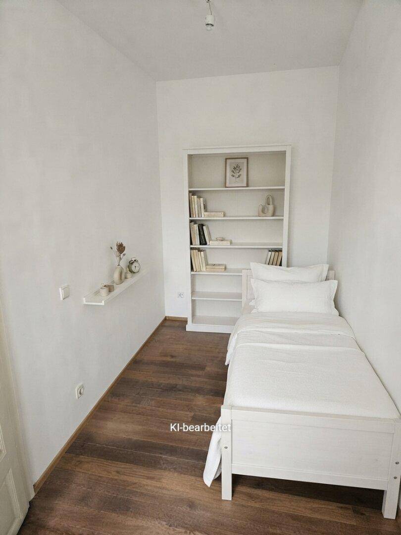 Gemütliches kleines Schlafzimmer mit Einzelbett, Bücherregal und Holzboden.