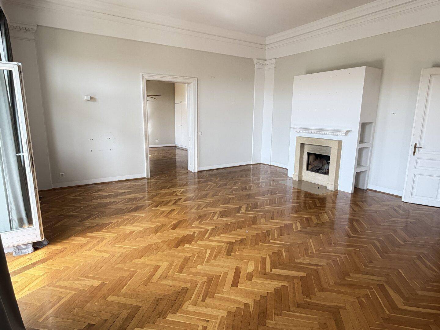 Elegantes Wohnzimmer mit Fischgrätparkett und einem integrierten Kamin für gemütliche Abende.