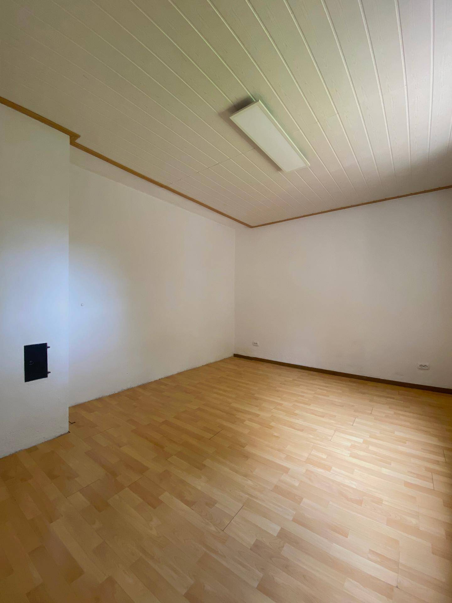 Helles Schlafzimmer mit Laminatboden und weißer Deckenverkleidung, ideal für Ruhe und Entspannung.