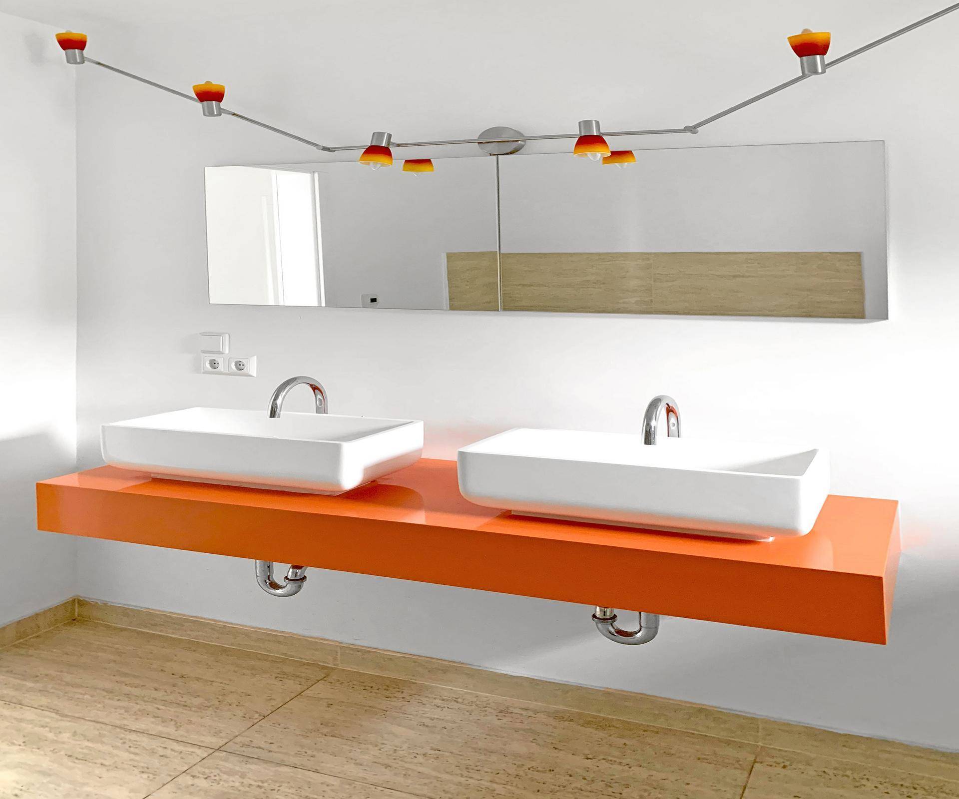 Modernes Badezimmer mit Doppelwaschbecken auf orangefarbener Konsole und Spiegelschrank.