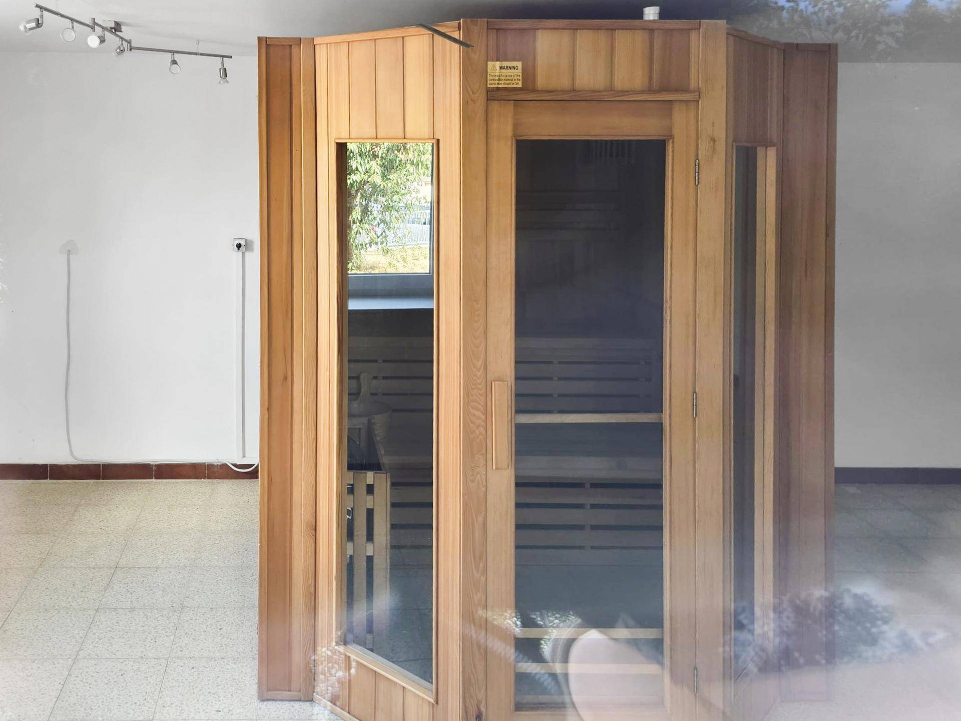Raum mit einer modernen Holzsauna, die zum Entspannen einlädt.
