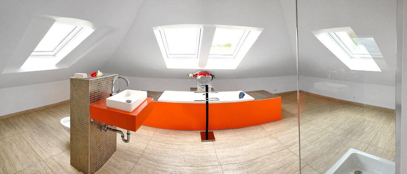 Modernes Dachgeschossbad mit freistehender Badewanne, Waschtisch und Dachfenstern.