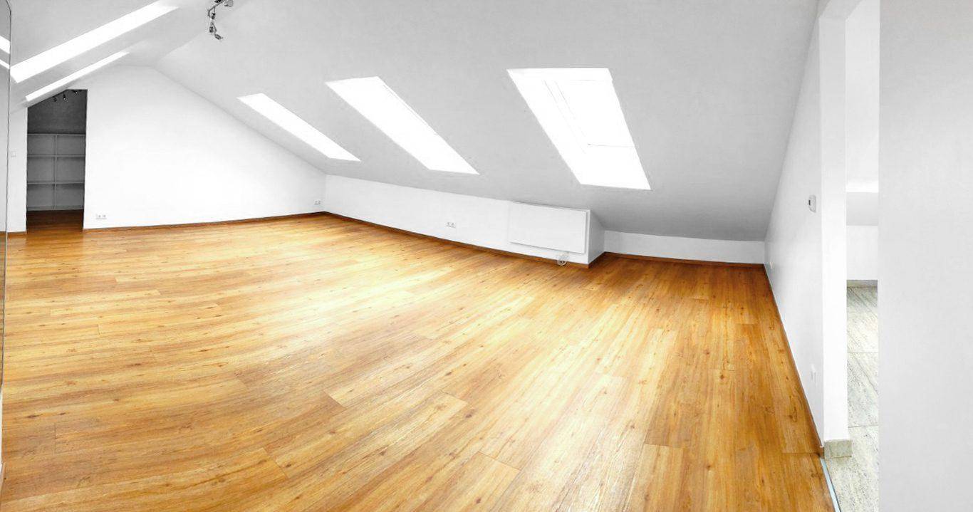 Geräumiges Dachgeschoss mit Laminatboden, Dachschrägen und viel Tageslicht durch die Fenster.
