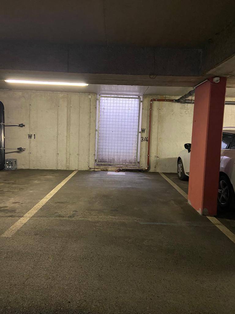 Geräumige Tiefgarage mit markierten Stellplätzen und Betonwänden.
