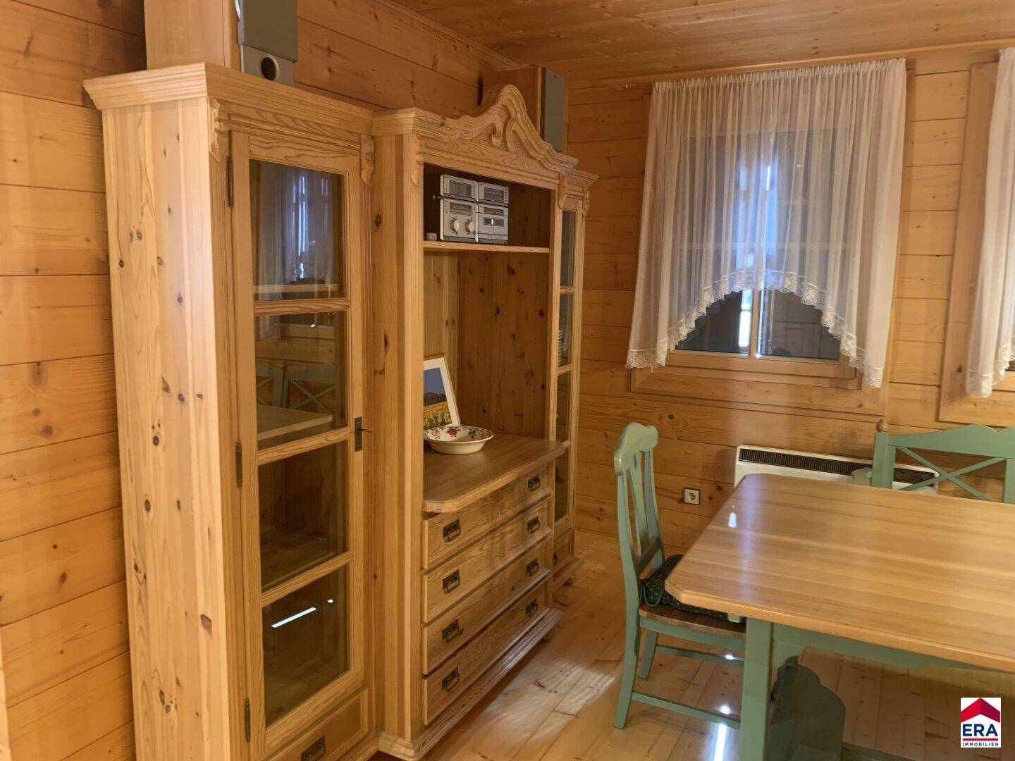 Essbereich mit traditionellen Holzmöbeln und Holzwänden, hell beleuchtet.
