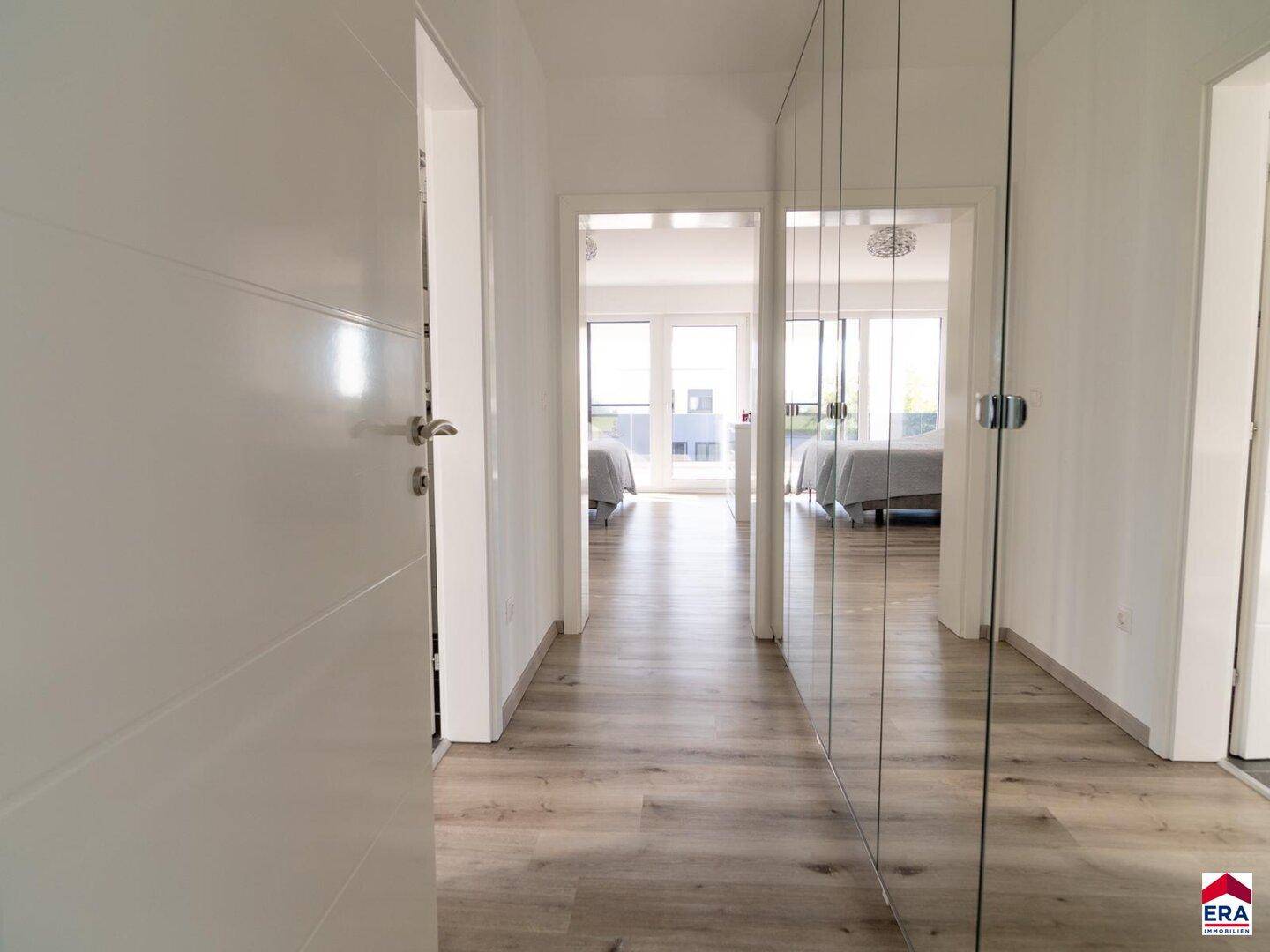 Heller Flur mit Spiegelschränken und Blick in die angrenzenden Schlafzimmer.