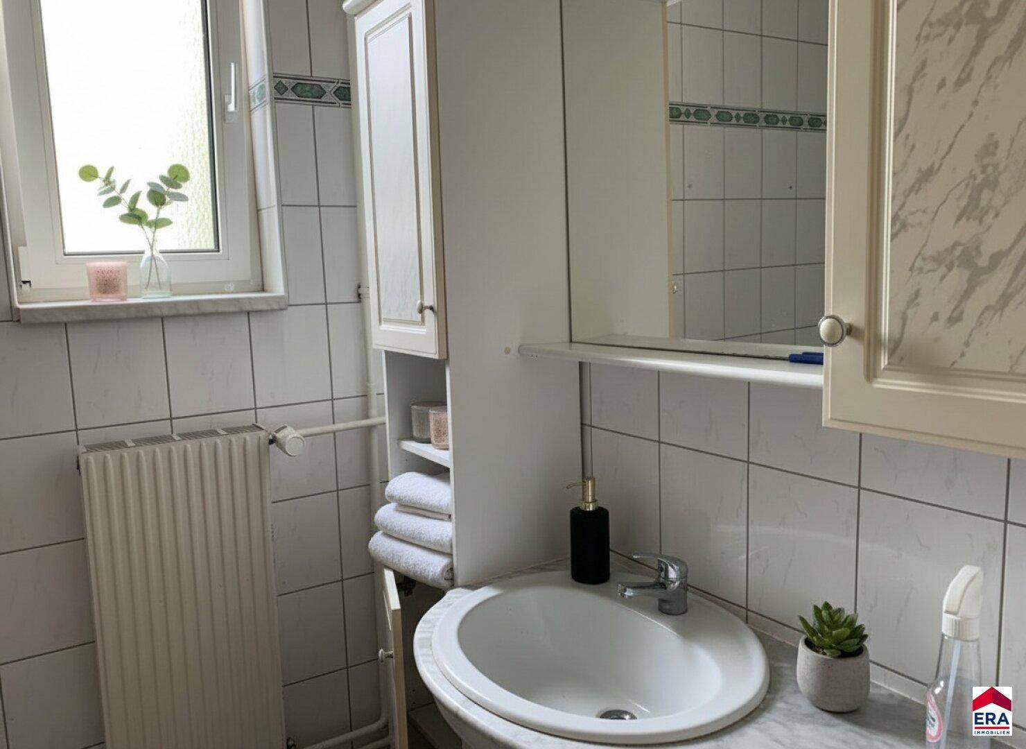 Badezimmer mit Waschbecken, Spiegelschrank und Fenster, gefliest in weißem Marmor-Look.