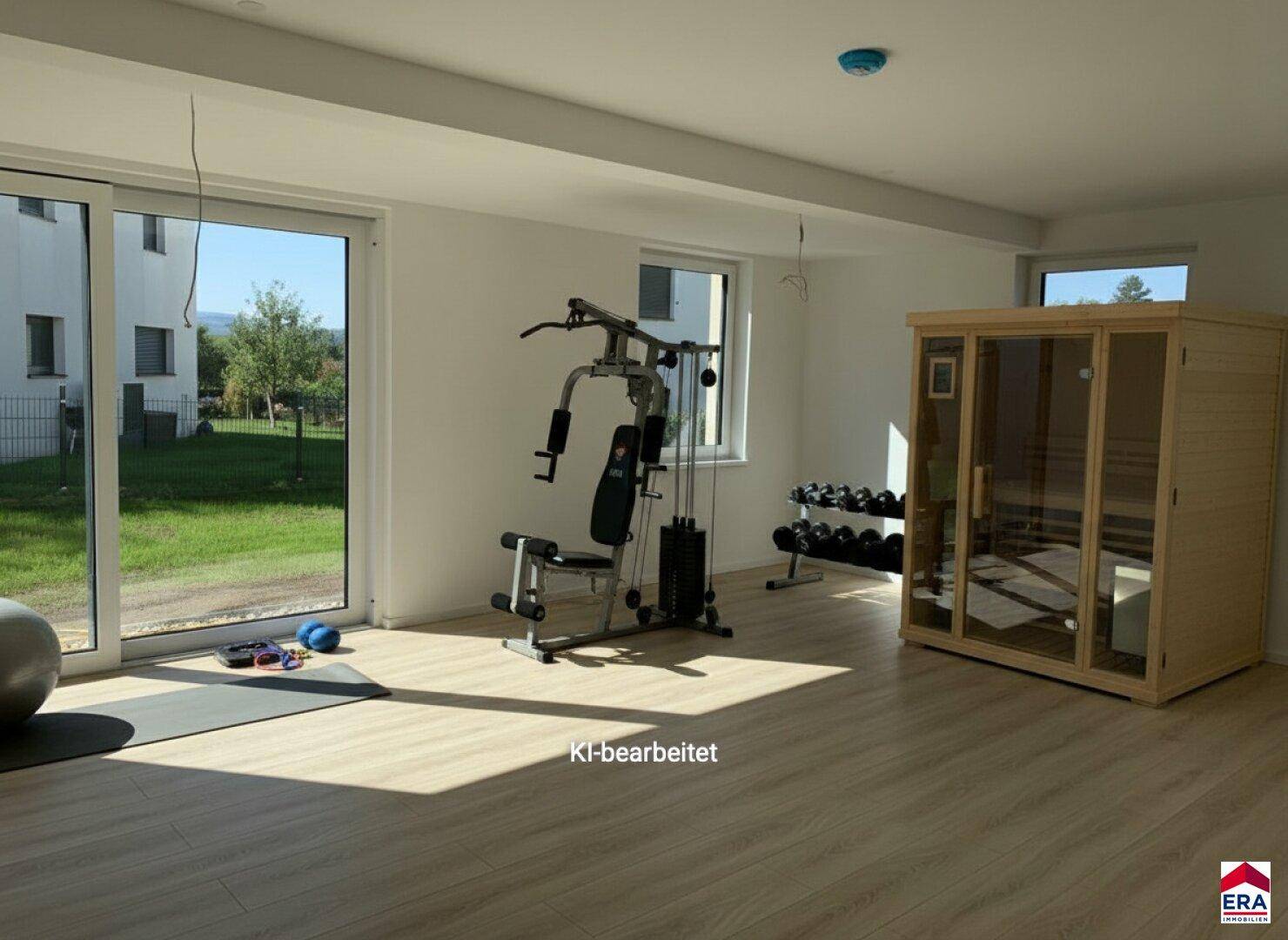 Geräumiger Fitnessraum mit Trainingsgeräten, Laminatboden und einer privaten Sauna für Wellness.