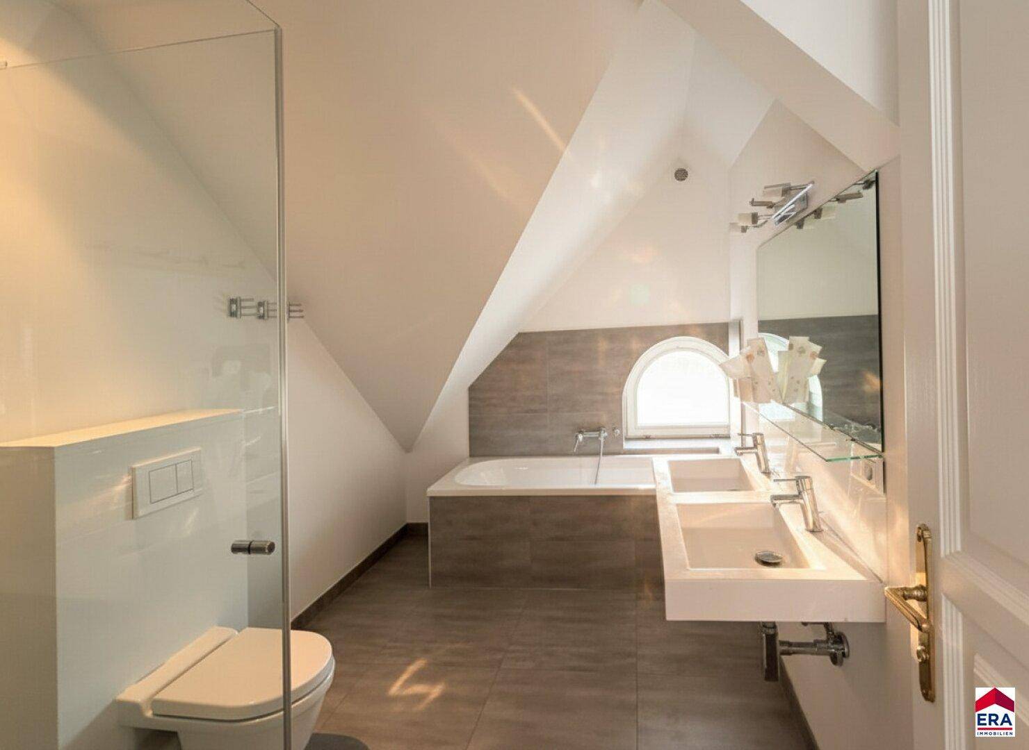 Modernes Dachgeschossbad mit Badewanne, Doppelwaschbecken und separater Dusche.