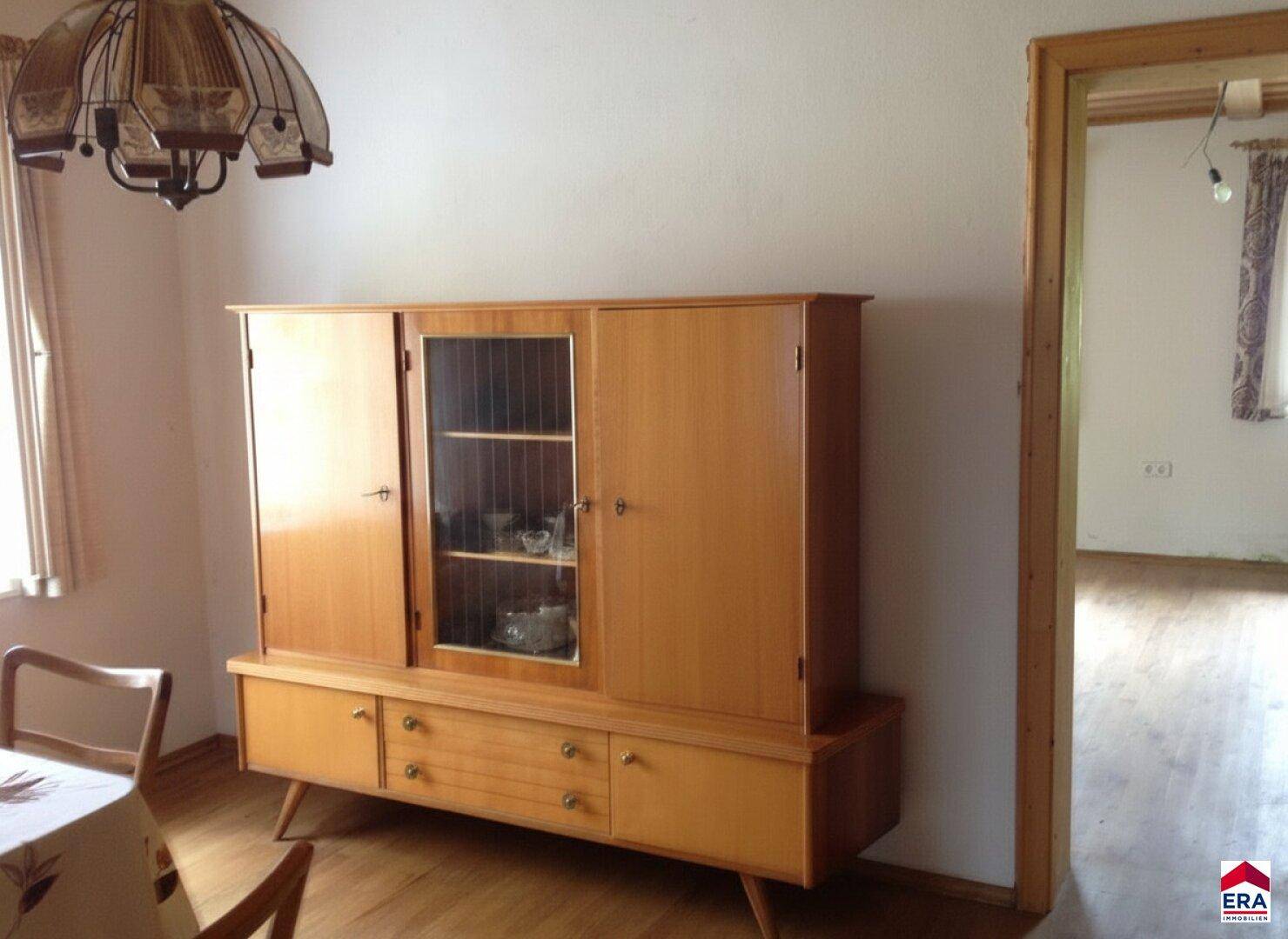 Essbereich mit einem traditionellen Holzschrank und Holzboden, der zu gemütlichen Mahlzeiten einlädt.