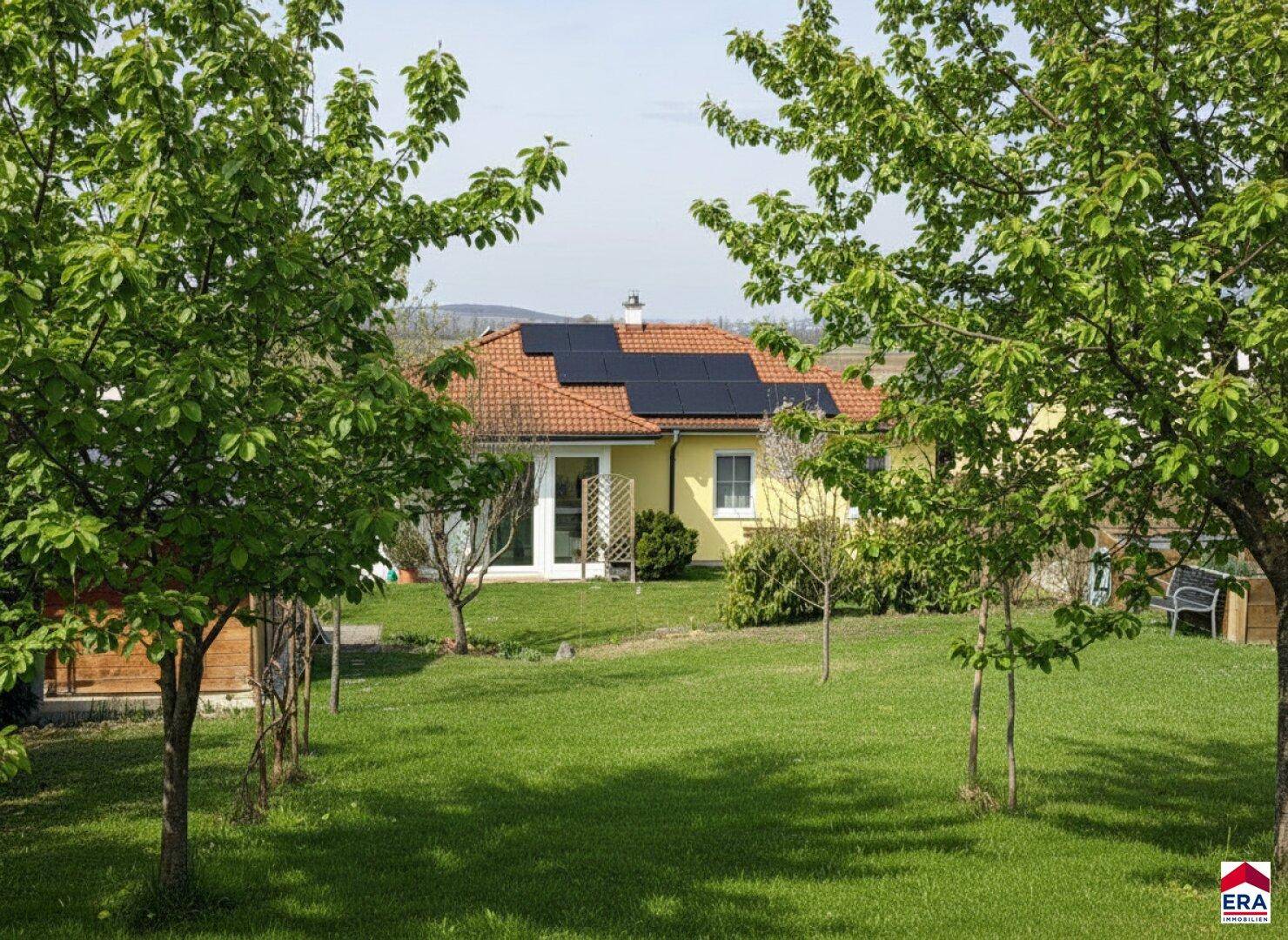 Weitläufiger Garten mit Obstbäumen und Blick auf das charmante Einfamilienhaus.