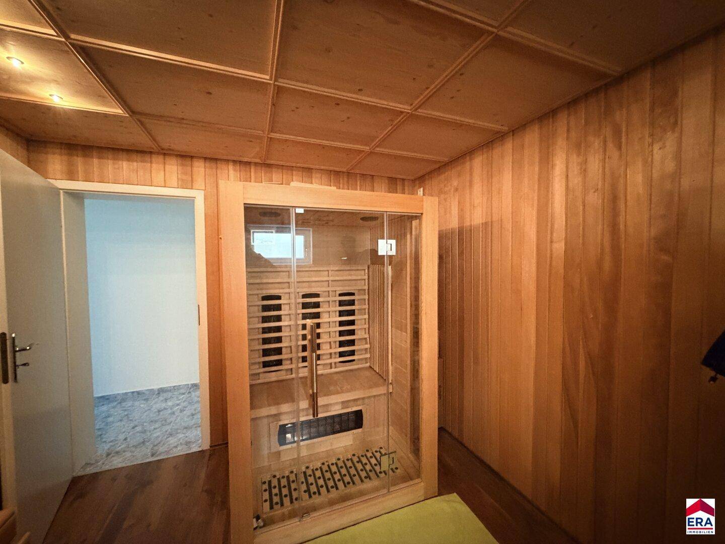 Gemütlicher Saunabereich mit Holzverkleidung und Infrarotkabine für Entspannung.