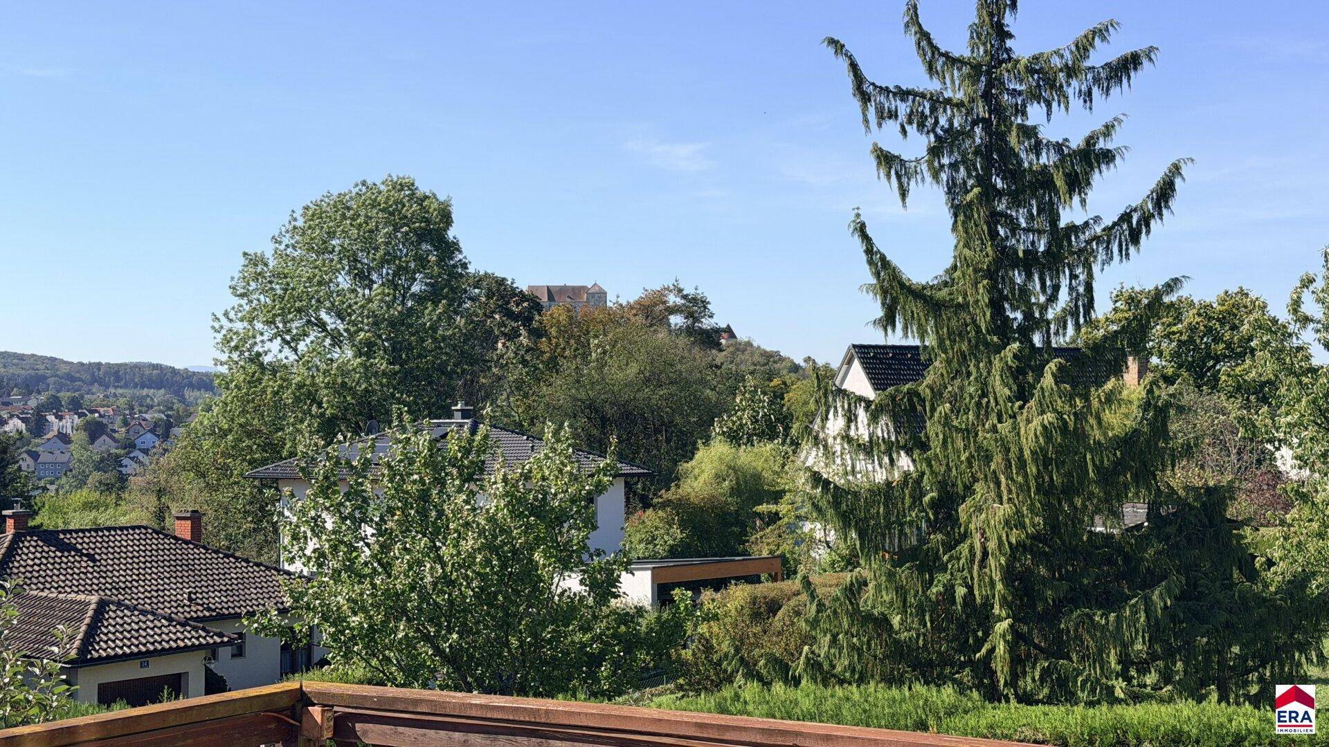 Malerischer Ausblick auf die umliegende grüne Landschaft und entfernte Gebäude.