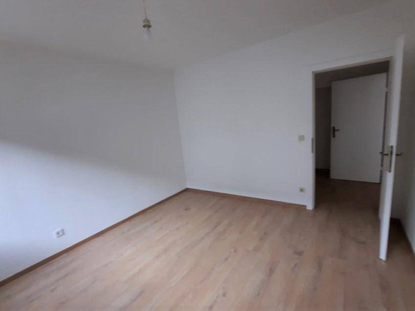 Geräumiges Schlafzimmer mit Laminatboden und weiß gestrichenen Wänden.