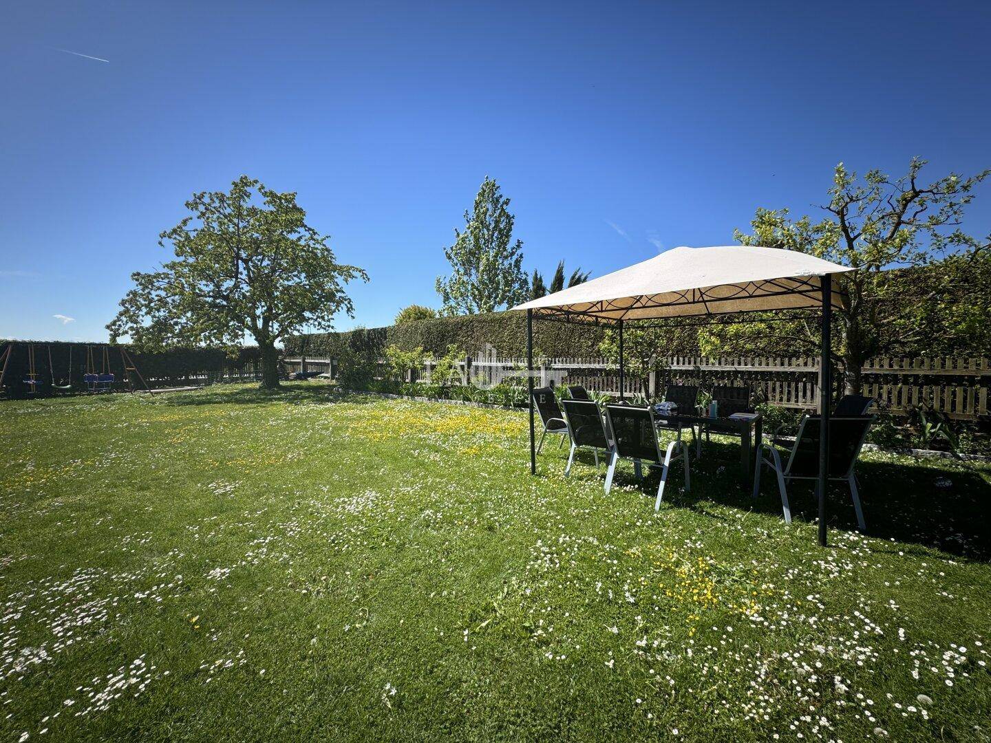 Großer Garten mit Rasenfläche, Pavillon und Sitzgelegenheiten für entspannte Stunden.