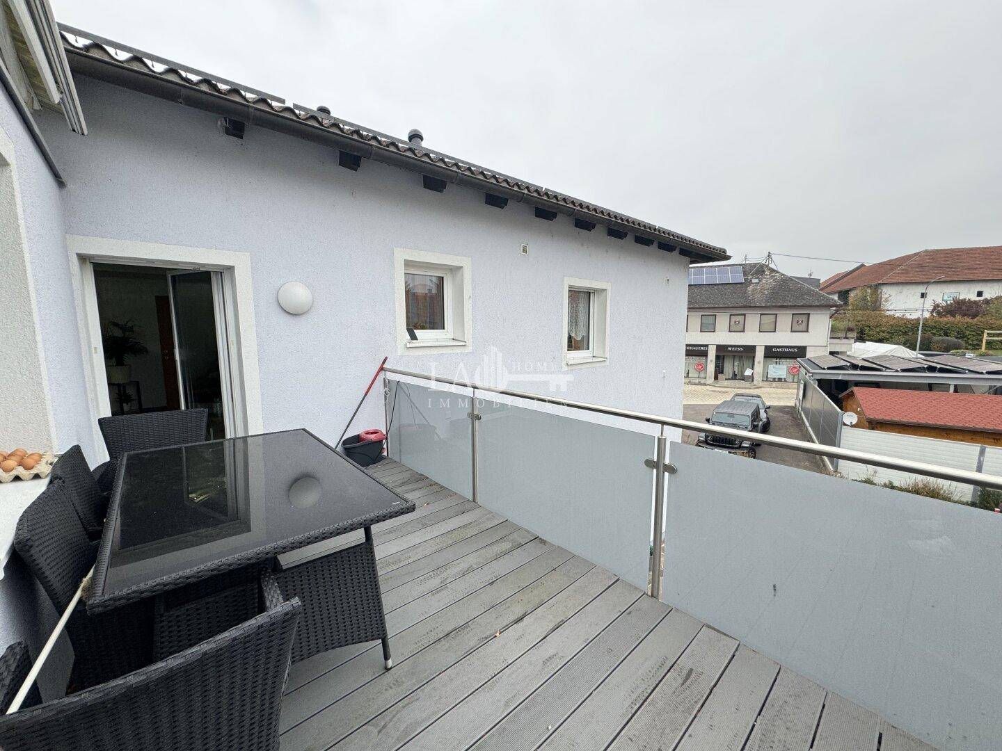 Balkon mit Outdoor-Sitzgelegenheiten und Blick auf die Umgebung, ideal zum Entspannen.