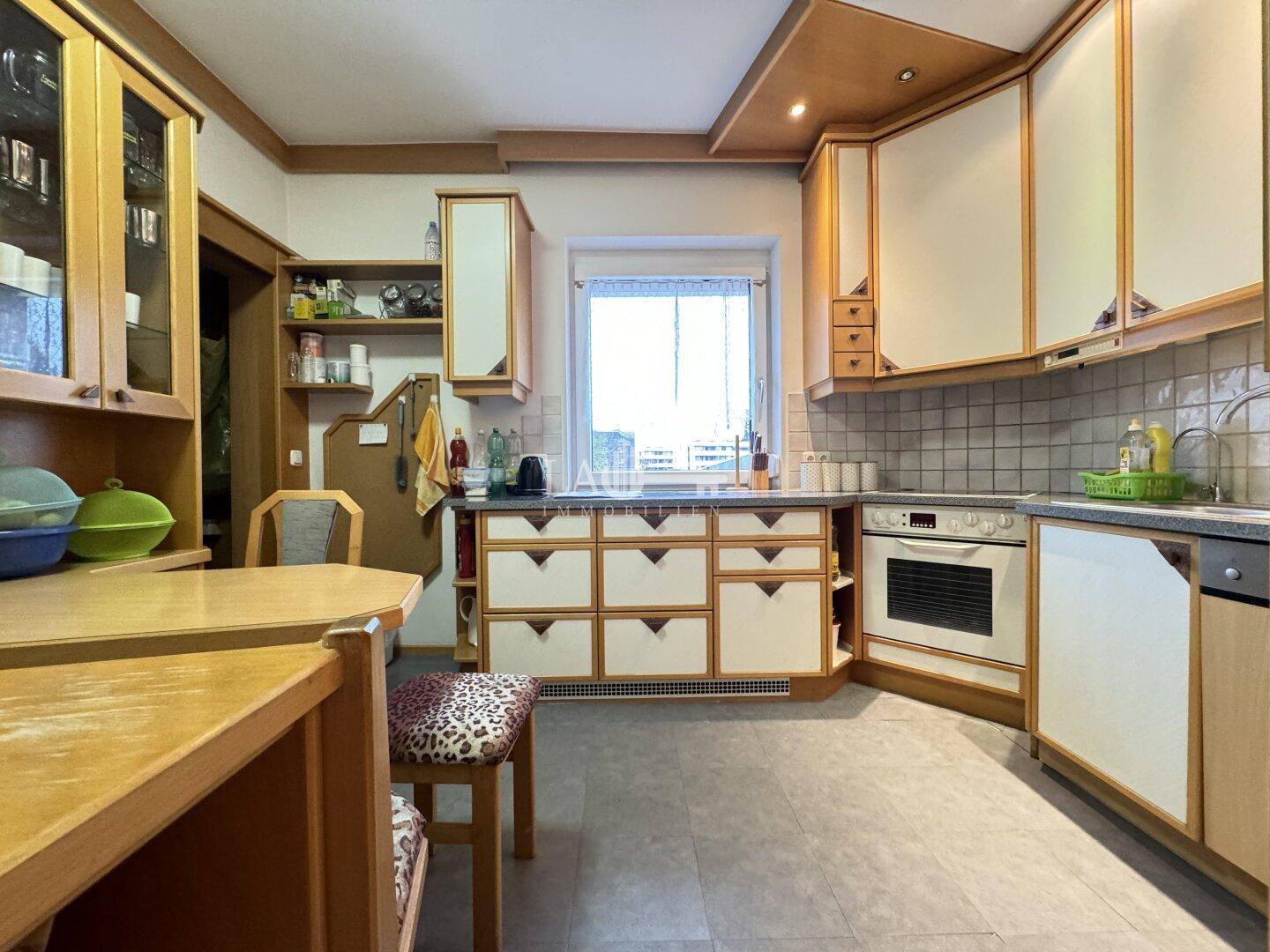 Traditionelle Küche mit Holzschränken, gefliestem Spritzschutz und integriertem Backofen.