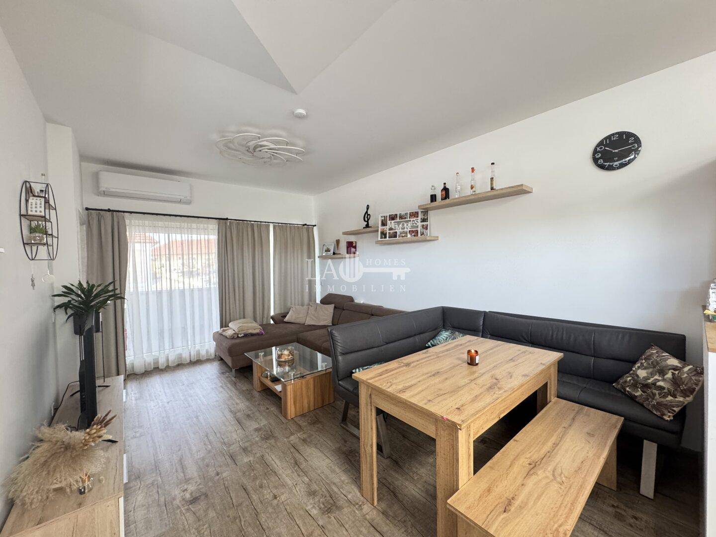 Gemütlicher Essbereich mit Holztisch und Eckbank, angrenzend an den Wohnbereich mit Sofa.