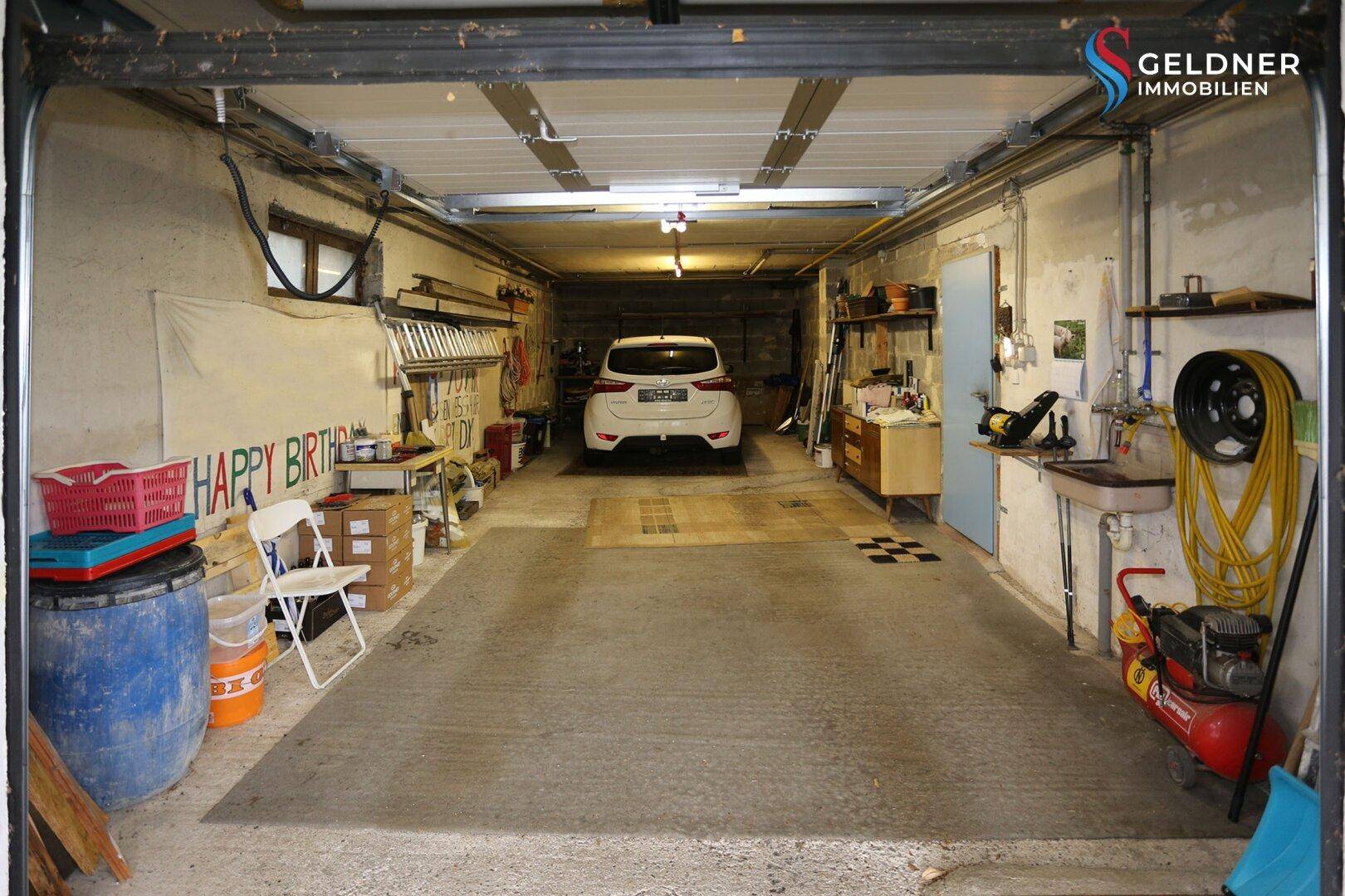 Geräumige Garage mit Platz für ein Fahrzeug und Werkstattbereich.