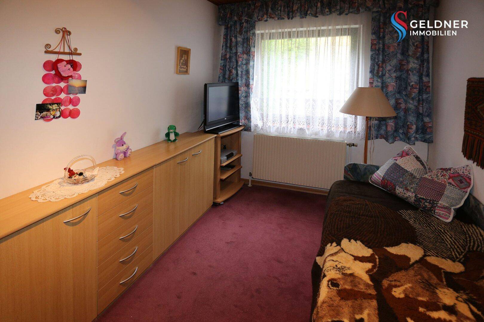 Weiteres Schlafzimmer mit Einzelbett, Teppichboden und langen Schränken.