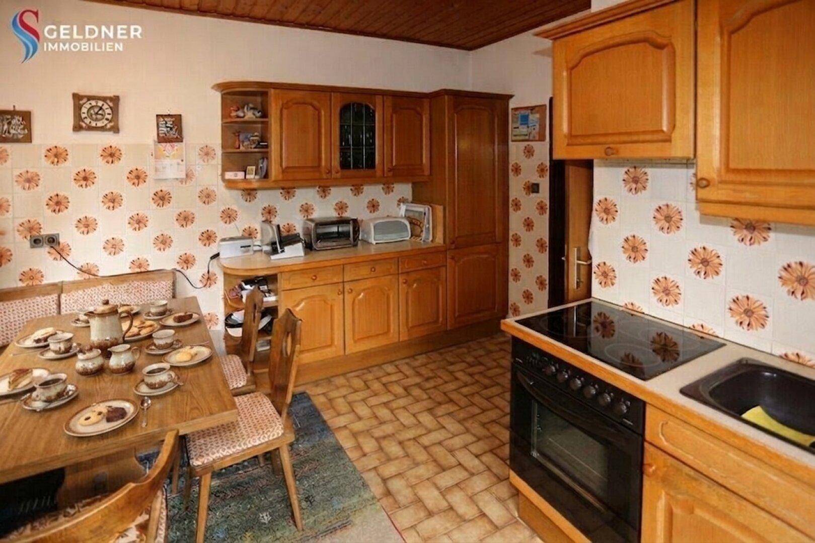 Gemütliche Wohnküche mit Essbereich, Holzmöbeln und traditioneller Einrichtung.