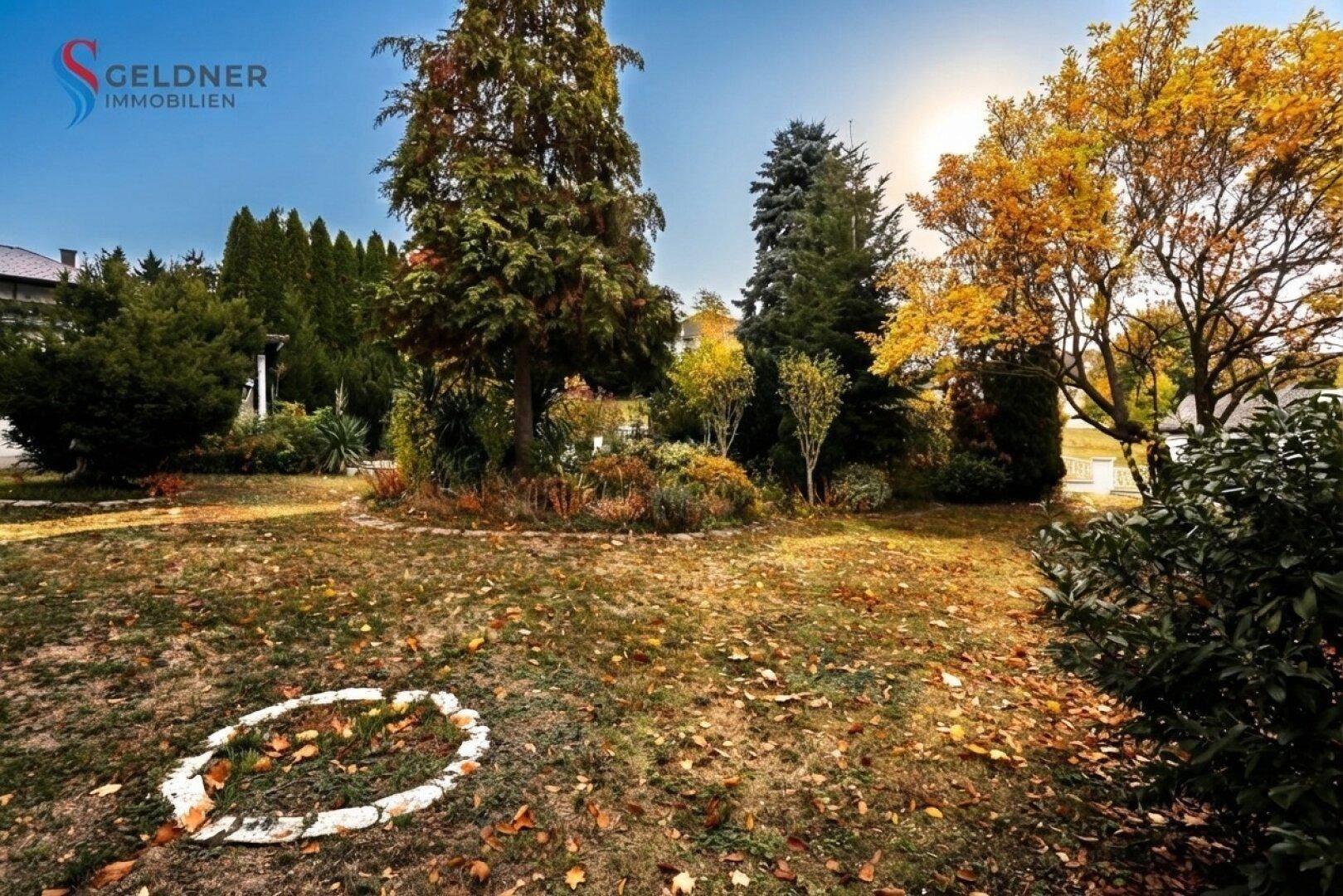 Weitläufiger Gartenbereich mit herbstlicher Bepflanzung und sonnigem Ausblick in die Natur.