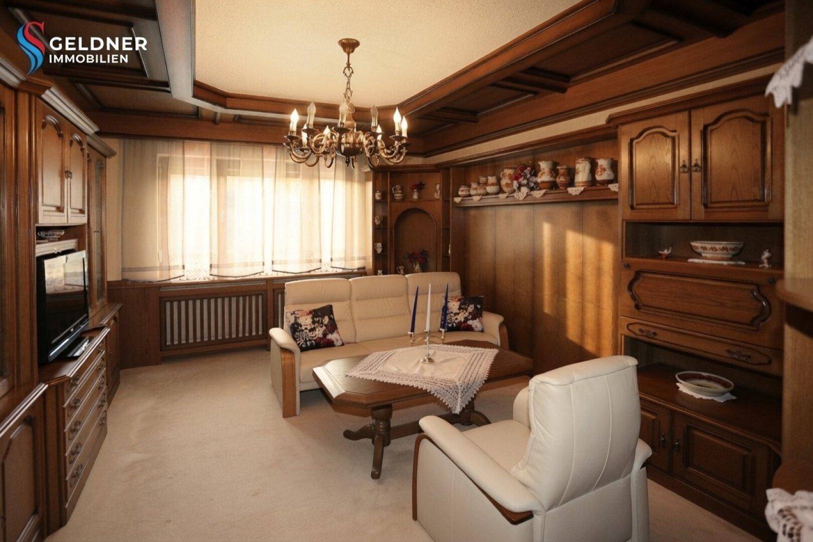 Gemütliches Wohnzimmer mit Holzvertäfelung, Sofa und Sessel, in einem traditionellen Stil eingerichtet.