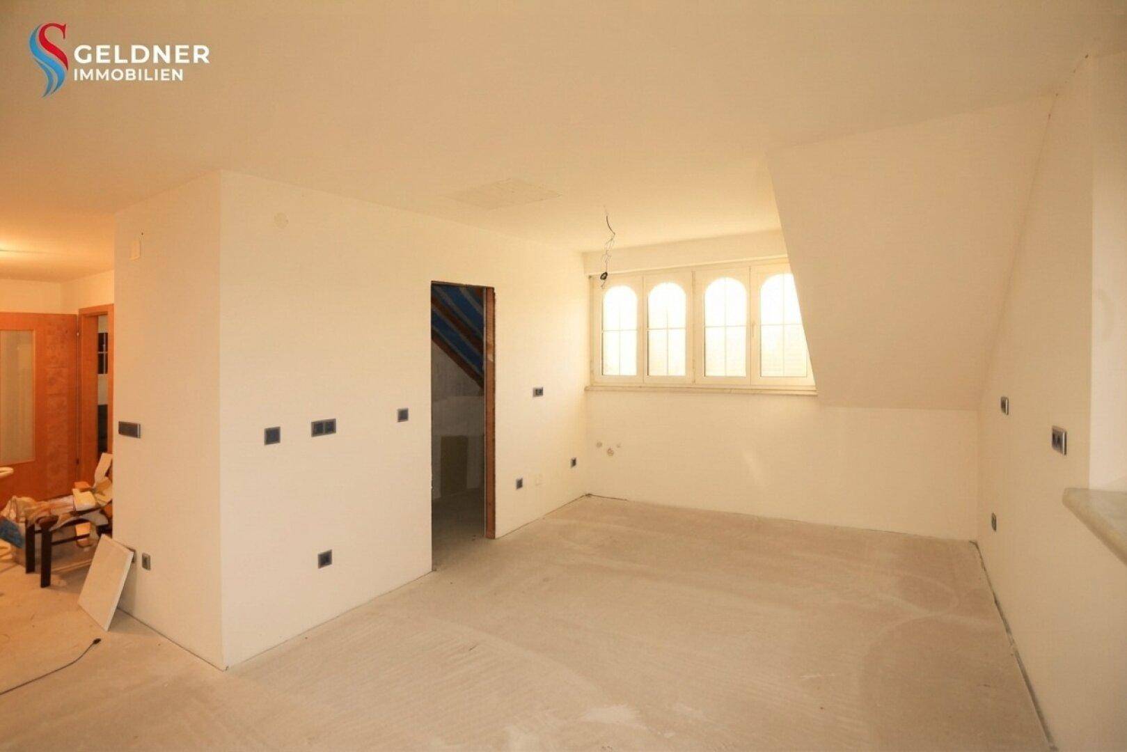Geräumiger Dachbodenraum mit schrägen Wänden und Fenstern, ideal für den Ausbau und individuelle Gestaltung.