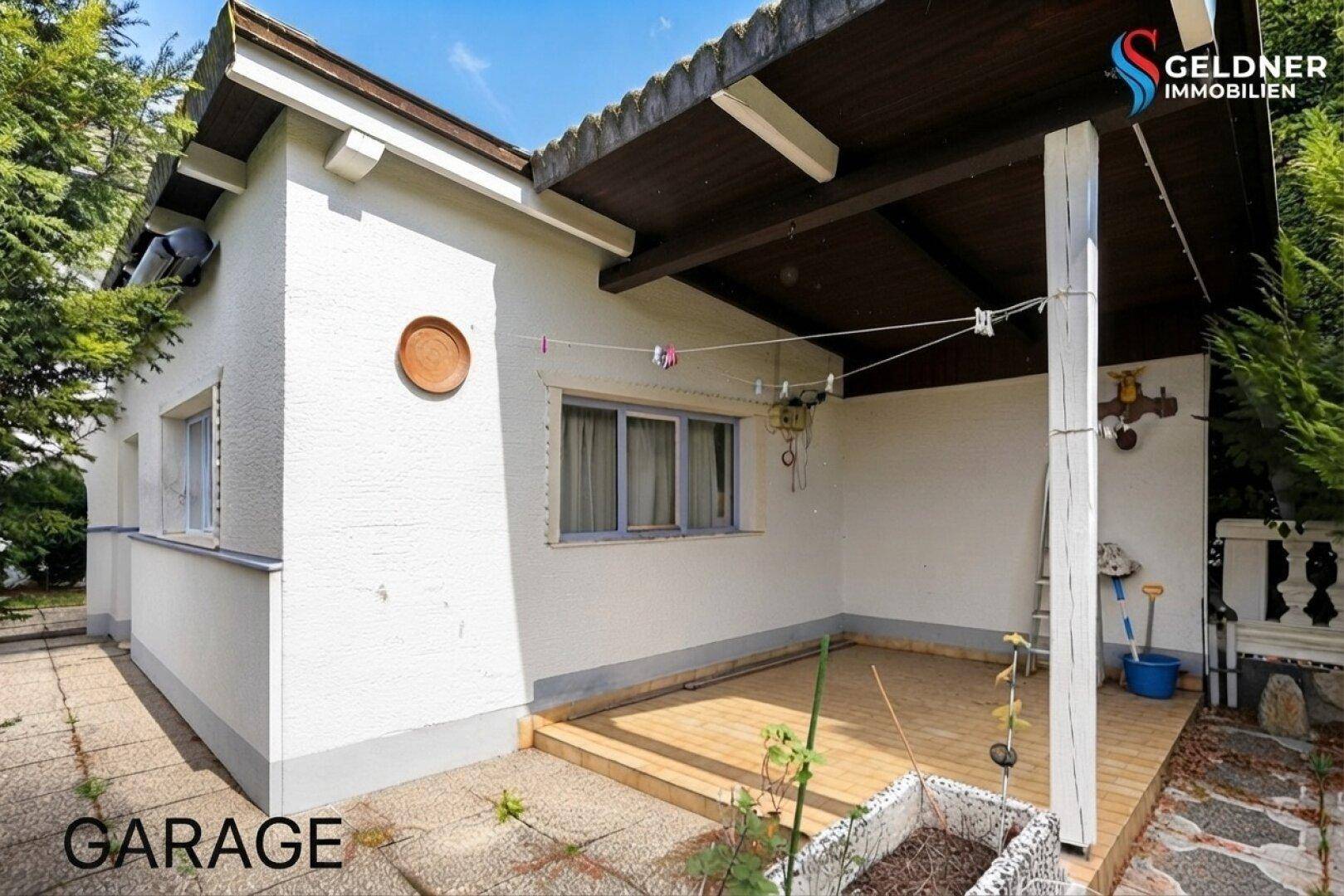 Kleines Nebengebäude oder Garage mit überdachtem Bereich und angrenzender Terrasse.