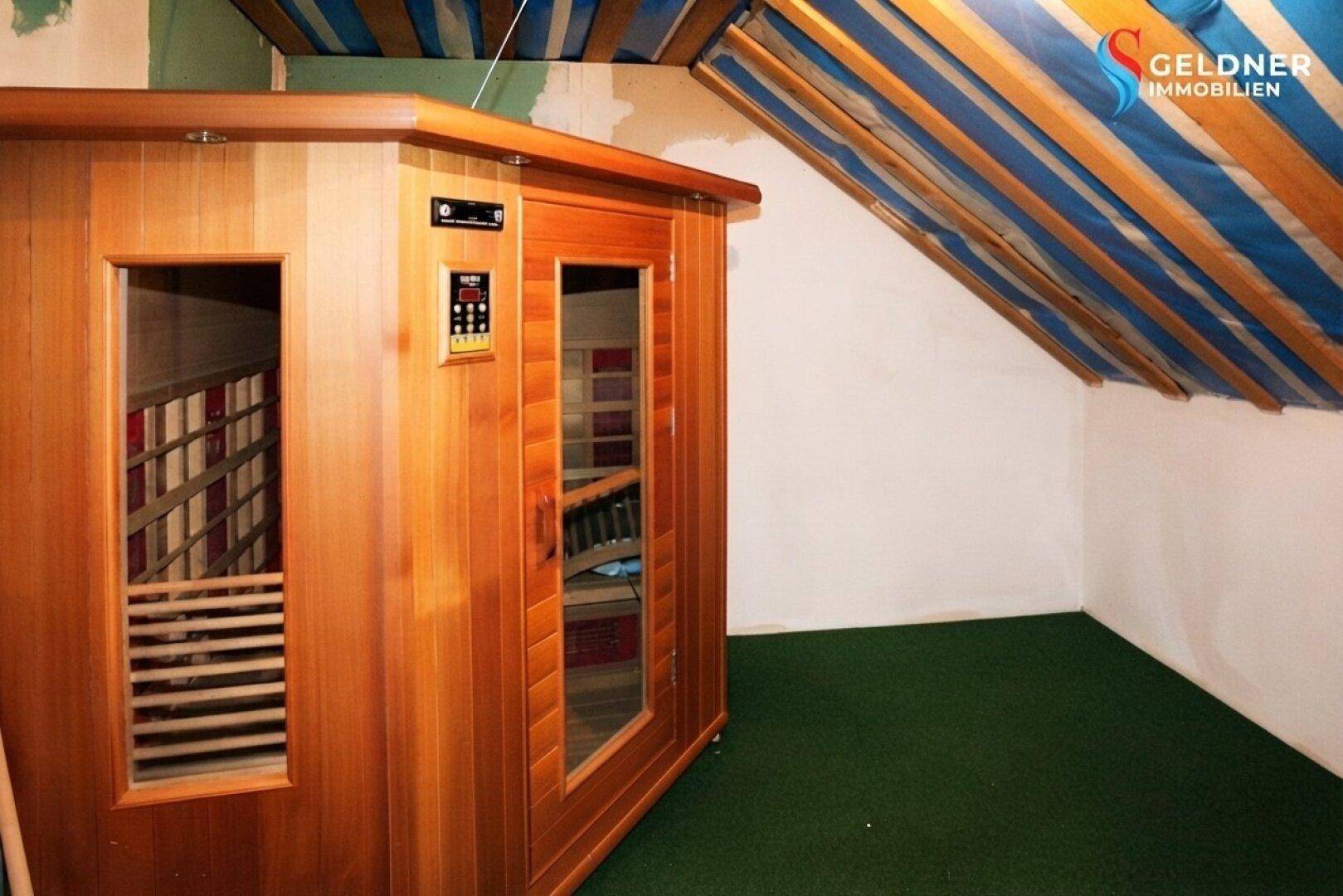 Dachboden mit einer Sauna und sichtbaren Dachbalken, bereit für den Ausbau und Wellnessbereich.