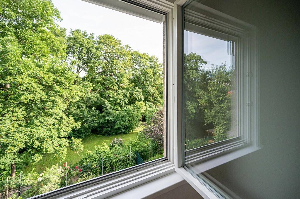 Fenster mit Blick auf üppiges Grün und einen gepflegten Gartenbereich, der viel Natur bietet.