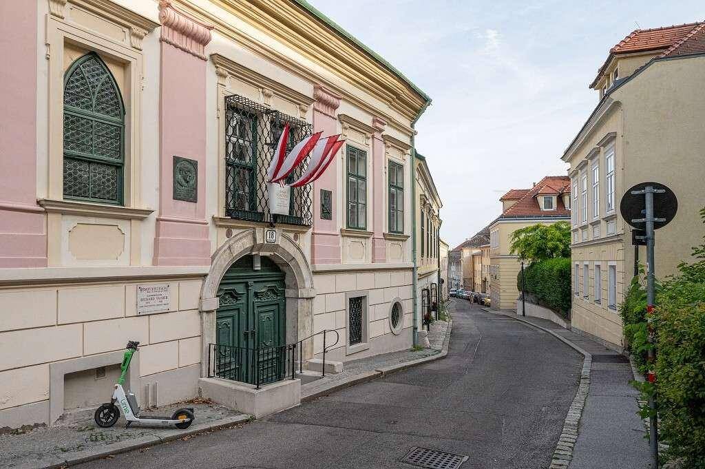 Historische Straße mit charmanten Gebäuden und österreichischen Flaggen an der Fassade.