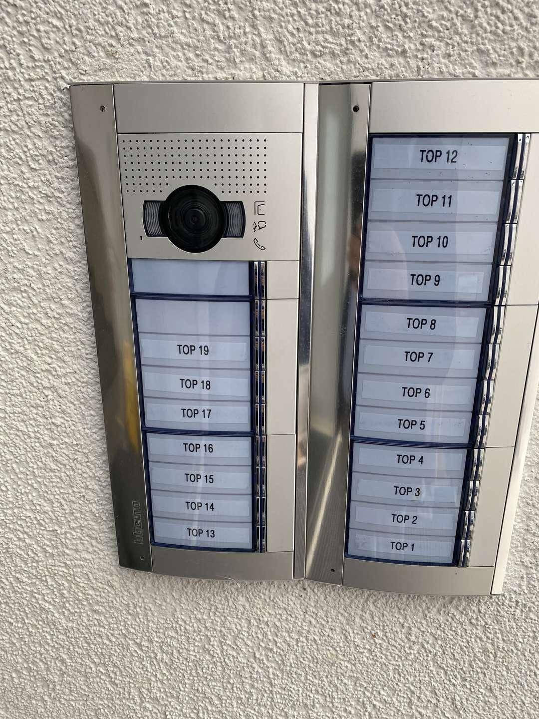 Moderne Gegensprechanlage mit Kamera und Klingeltableau für mehrere Wohneinheiten am Eingang.