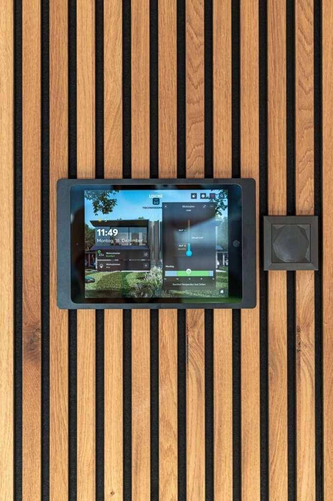 Smart-Home-Steuerungssystem an einer Wand mit Holzlamellen für moderne Wohnkonzepte.
