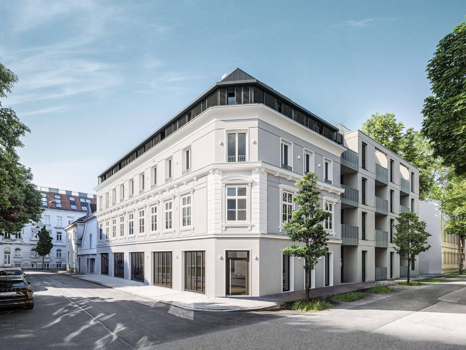 Gebäudefassade mit einer harmonischen Mischung aus klassischer und moderner Architektur, umgeben von Bäumen.