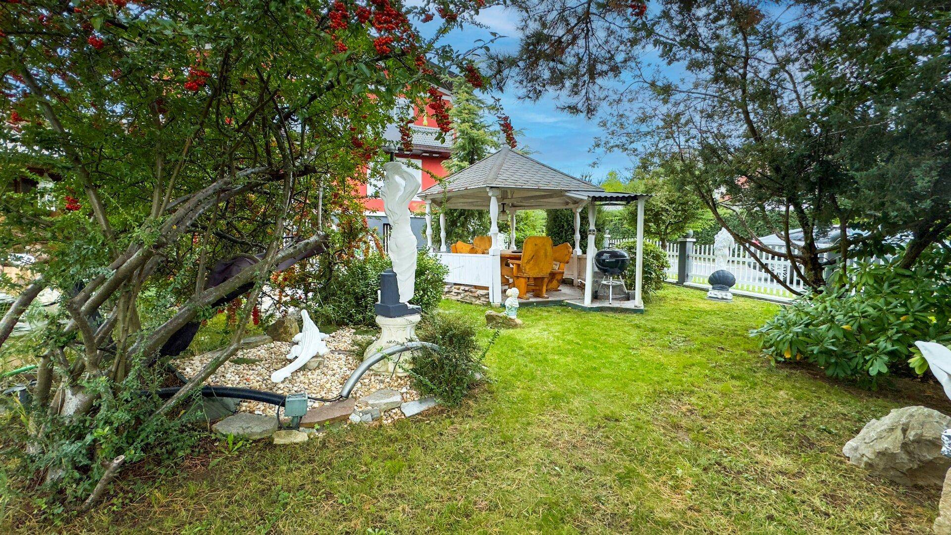 Weitläufiger Garten mit Rasenfläche, einem Pavillon und einem Grillbereich für gesellige Abende.