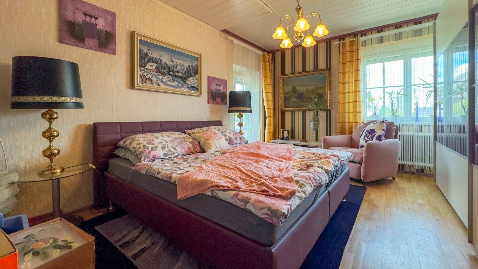 Gemütliches Schlafzimmer mit Holzboden, Doppelbett und traditioneller Einrichtung.