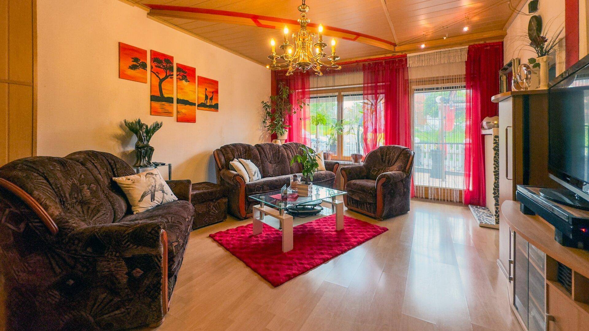 Traditionelles Wohnzimmer mit Holzboden, bequemen Sofas und einem Kronleuchter.