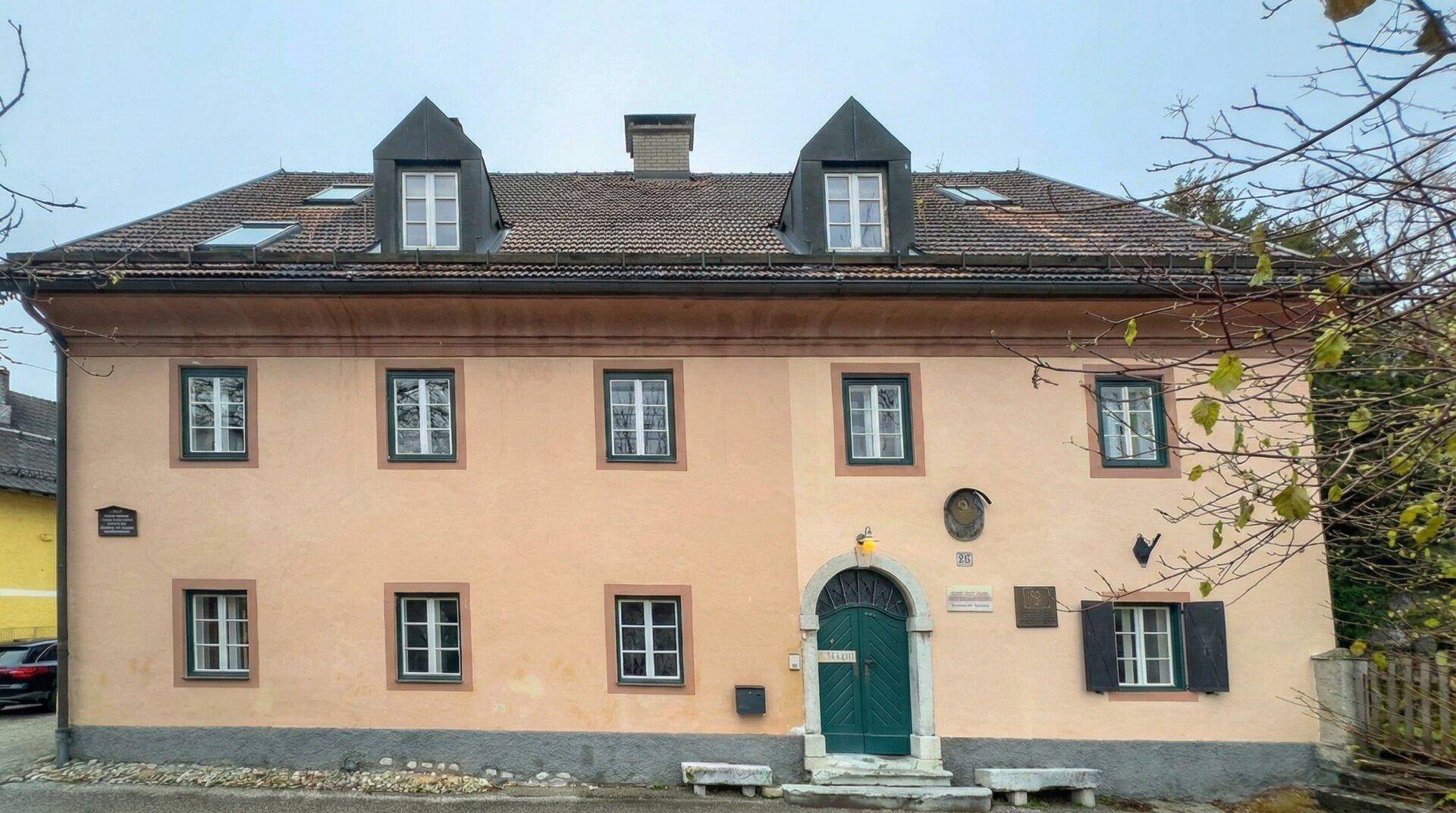 Altes, charmantes Gebäude mit traditioneller Architektur, mehreren Fenstern und einem markanten Eingang.