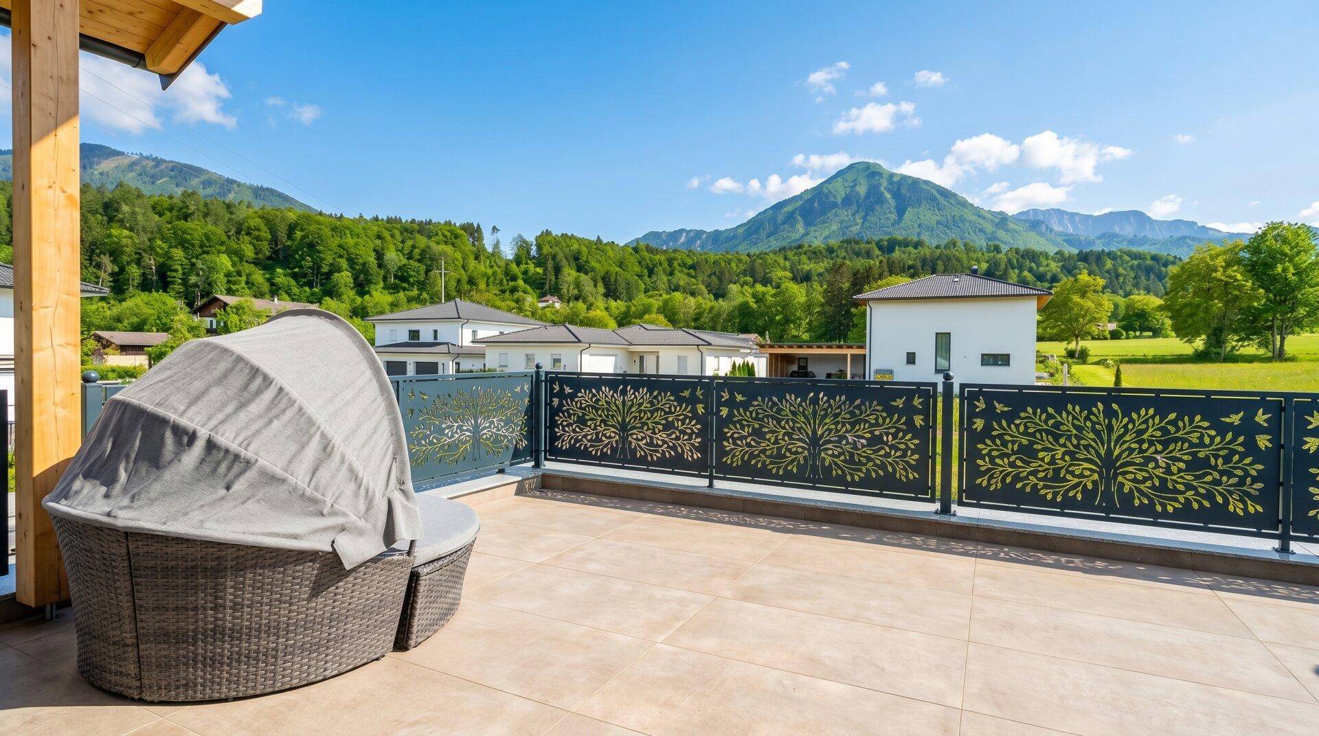Große Dachterrasse mit Liegemöbeln, dekorativem Geländer und weitem Bergblick.